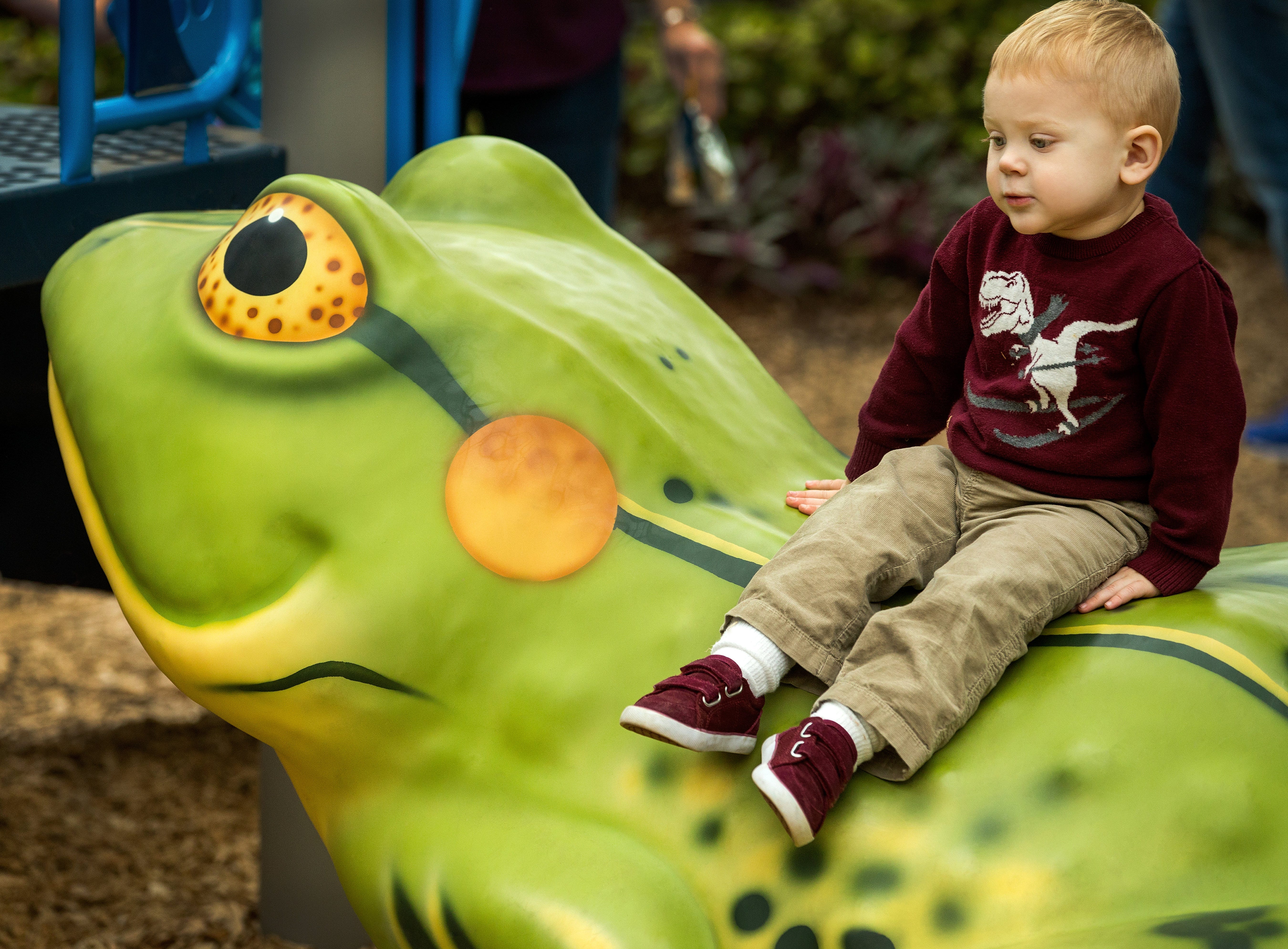 Child sitting on a frog-shaped Fun Forms playground sculpture