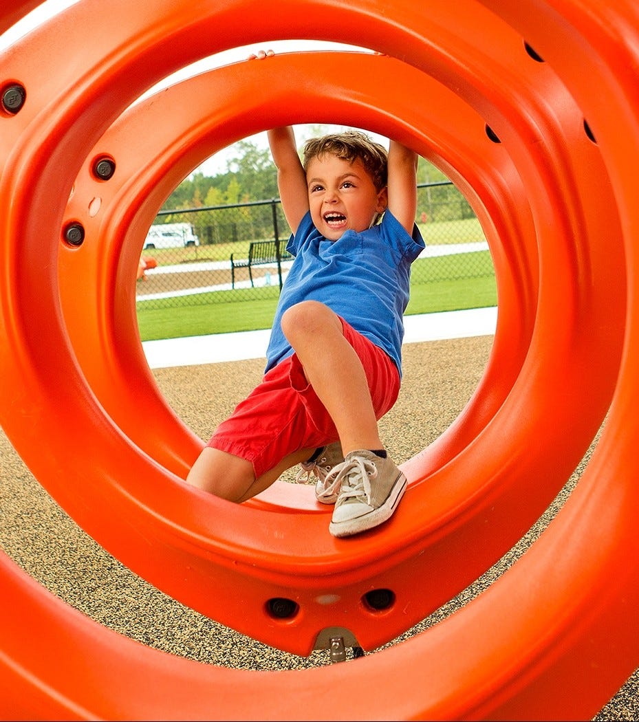 Children playing on Xscape fitness-inspired playground equipment