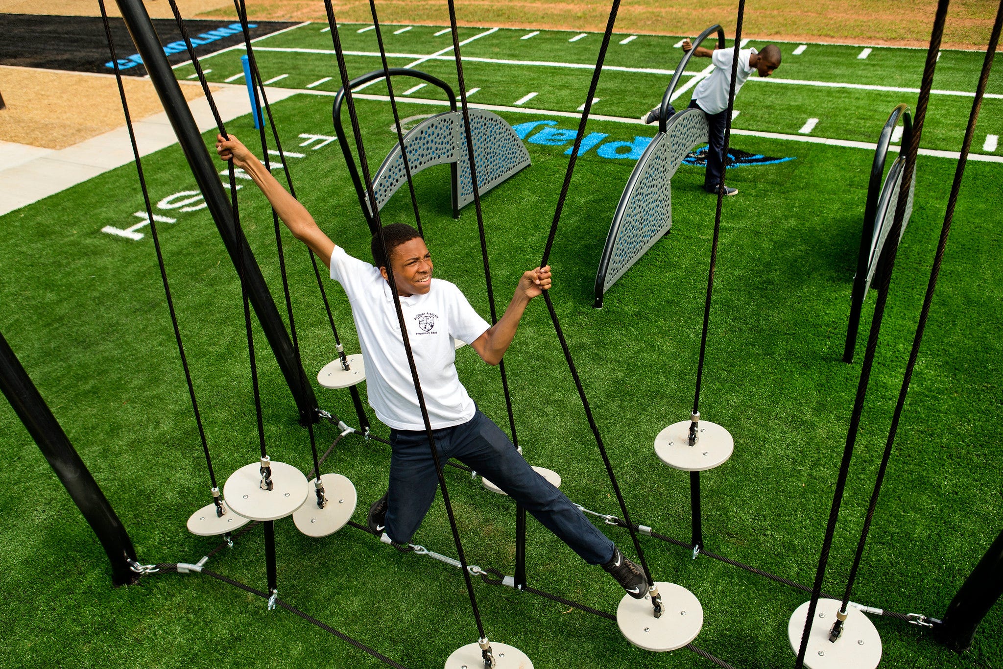 Teen boys running a challenge course obstacle course