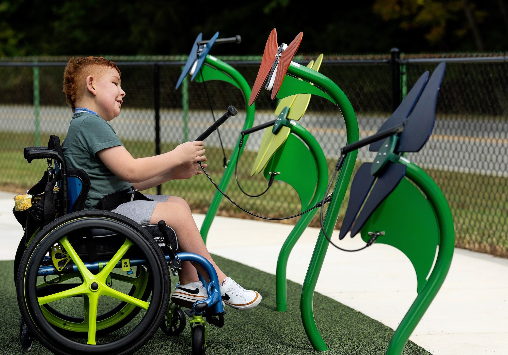 Child smiling on an inclusive playground swing