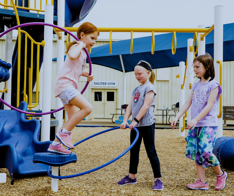 Children using outdoor playground equipment designed for active play